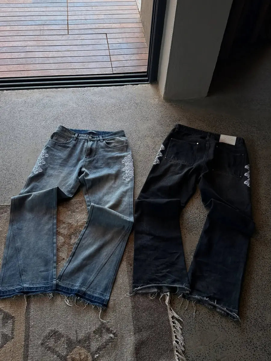 Two pairs of reda studio flare jeans laid flat, one blue wash and one black